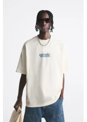 The Champ Clothing تي شيرت رجالي أبيض كبير الحجم مطبوع عليه سجلات Peanuts برقبة دائرية