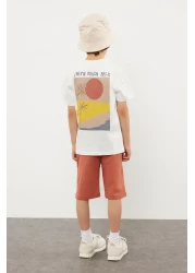 TRENDYOLKIDS طقم محبوك باللون الأزرق الداكن للأولاد - تي شيرت وسروال قصير مصنوع من القطن بنسبة 100% مع طباعة خلفية TKDSS24AU00008