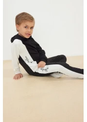 TRENDYOLKIDS طقم سويت شيرت وبدلة رياضية بغطاء للرأس من القطن باللون الأسود للأولاد - TKDAW25AU00058