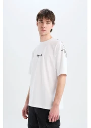 Defacto تي شيرت قطن 100% كبير الحجم بقصة واسعة وياقة دائرية وطباعة خلفية وأكمام قصيرة D5600ax25sp