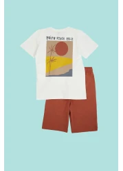 TRENDYOLKIDS طقم محبوك باللون الأزرق الداكن للأولاد - تي شيرت وسروال قصير مصنوع من القطن بنسبة 100% مع طباعة خلفية TKDSS24AU00008